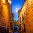 Un detaliu al Puerta de Santiago dezvăluie vechiul pasaj fortificat din Trujillo, încadrat de ziduri înalte din piatră, arcade medievale și portaluri istorice ale orașului fortificat.
