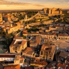 Trujillo se dezvăluie de sus prin Plaza Mayor renascentistă, palatele nobiliare și castelul de origine islamică, legat de vechea incintă fortificată prin turnuri și drumuri de strajă medievale.