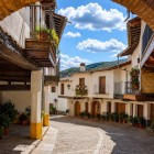 Un vechi arc din cărămidă deschide o stradă din Guadalupe, unde casele medievale, balcoanele din lemn și pridvoarele tradiționale păstrează farmecul autentic al regiunii Extremadura din Spania.