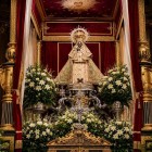 Fecioara Neagră din Guadalupe domină altarul principal al Mănăstirii Regale, între candelabre, flori și draperii prețioase, simbol al devoțiunii mariane din Extremadura.