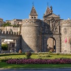 Puerta Nueva de Bisagra, reconstruită în secolul al XVI-lea după proiectul lui Covarrubias, întâmpină vizitatorii orașului Toledo cu turnuri, arc de triumf, stemă imperială și o veche curte de arme.