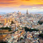 Văzut de sus, Toledo își dezvăluie inima medievală: acoperișuri de teracotă, biserici vechi și Catedrala se înalță peste centrul istoric, luminat de apus.