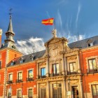 Fațada Palacio de Santa Cruz exprimă rigoarea Madridului habsburgic: cărămidă roșie, granit, balcoane ordonate și un portal sculptat, încununat de stema regală.