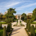 Parterul din El Retiro ordonează garduri vii sculptate și alei geometrice în stilul francez al secolului al XVIII-lea; monumentul lui Jacinto Benavente conduce privirea pe axa centrală.