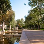 Paseo de Recoletos oferă un refugiu verde în inima Madridului: bazinele liniare, coloanele din piatră și copacii umbroși însoțesc plimbarea de-a lungul bulevardului istoric.