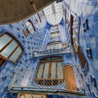 Curtea interioară a Casei Batlló se înalță spre lumină prin plăci ceramice în nuanțe graduale de albastru, ferestre sinuoase și balcoane ce reflectă limbajul organic al lui Gaudí.