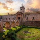 Castelul Montjuïc păstrează aspectul unei fortărețe din secolul al XVIII-lea: bastioanele din piatră, șanțul, podul de acces și geometria defensivă evocă trecutul militar al Barcelonei.