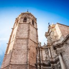 El Miguelete domină Catedrala din Valencia prin turnul său gotic octogonal din secolul al XIV-lea; alături, fațada barocă a Porții de Fier completează profilul monumental.