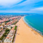 Vedere asupra Valenciei și a cartierului Malvarrosa, cu plaja sa întinsă, promenada animată și Casa Muzeu Blasco Ibáñez, care dezvăluie identitatea maritimă și culturală a orașului.