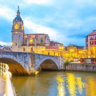 Biserica și Podul San Antón se înalță deasupra estuarului Bilbao, evocând originile medievale ale orașului prin arcade de piatră, turnul baroc și centrul vechi.