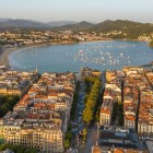Văzut de sus, San Sebastián se deschide spre golful La Concha, printre bulevarde elegante, clădiri ordonate, plaje aurii și ambarcațiuni pe Marea Cantabrică.