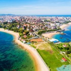 Vedere aeriană asupra orașului Santander, capitala Cantabriei, cu plaje aurii, Marea Cantabrică și cartiere de coastă unde peisajul urban întâlnește natura.