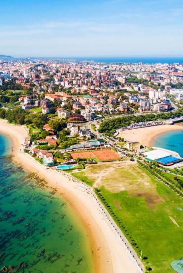 Vedere aeriană asupra orașului Santander, capitala Cantabriei, cu plaje aurii, Marea Cantabrică și cartiere de coastă unde peisajul urban întâlnește natura.