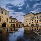 La apus, piața medievală din Santillana del Mar se reflectă pe pavajul umed. În inima Cantabriei, localitatea este o oprire fermecătoare pe Drumul de Nord.