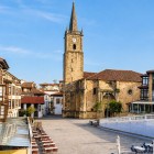 Plaza de la Constitución, inima orașului Comillas, invită la plimbări printre case cantabrice și terase, sub turnul istoric din piatră al bisericii San Cristóbal.