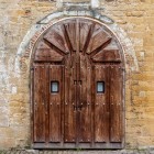 Portalul bisericii San Miguel de Lillo păstrează o intrare sobră și intimă: arcul din piatră și ușa masivă din lemn conduc spre liniștea sanctuarului de pe Naranco.