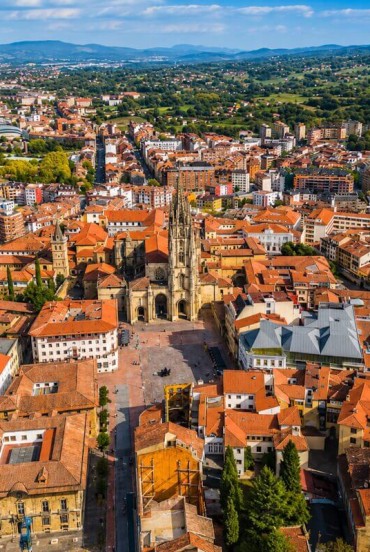 Văzut de sus, Oviedo își dezvăluie centrul istoric în jurul Catedralei San Salvador, printre acoperișuri, străzi vechi și peisajul verde al Asturiei.