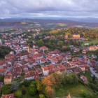Comillas se dezvăluie de sus printre acoperișuri roșii și dealuri verzi, cu centrul istoric adunat în jurul bisericii: un oraș cantabric unde tradiția maritimă întâlnește arhitectura.