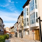 Calle de la Puebla, stradă pietonală din centrul istoric al orașului Burgos. Galeriile vitrate tradiționale conduc privirea spre biserica gotică San Lesmes, situată în Plaza de San Juan.