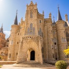 Palatul Episcopal din Astorga dezvăluie creativitatea lui Gaudí prin portalul evazat, turnurile cilindrice și creneluri, evocând o fortăreață medievală de poveste.