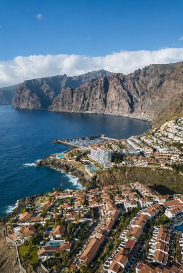 Impunătoarele faleze Los Gigantes se ridică deasupra Atlanticului, dominând portul turistic și casele din Puerto de Santiago, așezate de-a lungul spectaculoasei coaste vestice a insulei Tenerife.