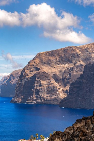 Impunătoarele stânci Los Gigantes se înalță deasupra Atlanticului, printre roci vulcanice, ape de un albastru intens și natura sălbatică a coastei vestice a insulei Tenerife.