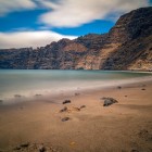 La poalele stâncilor Los Gigantes, o plajă cu nisip vulcanic se deschide spre Atlantic, oferind un peisaj spectaculos pe coasta vestică a insulei Tenerife.