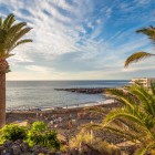 Playa de La Arena, din Puerto de Santiago, se deschide printre palmieri și roci vulcanice, cu nisipul său negru scăldat de Atlantic și luminat de razele calde ale soarelui.
