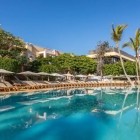 Înconjurată de palmieri și grădini luxuriante, una dintre piscinele hotelului de 4 stele Servatur Isora Suites oferă un refugiu liniștit în clima blândă din Puerto de Santiago.