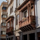 Elegantele balcoane canariene sculptate în lemn împodobesc fațadele centrului istoric din San Cristóbal de La Laguna, reflectând întâlnirea dintre arhitectura colonială și tradiția mudéjar.