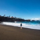 Pe Playa de La Arena din Puerto de Santiago, nisipul vulcanic întâlnește valurile Atlanticului: un peisaj luminos, ideal pentru plimbări și relaxare.