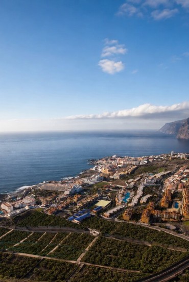 Văzut de sus, Puerto de Santiago se întinde între plantații de bananieri și ocean, iar Los Gigantes închide orizontul cu impunătoarele sale stânci vulcanice.