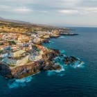 Văzută de sus, coasta din Puerto de Santiago urmează curgerile întunecate de lavă, unde Atlanticul se sparge în spumă turcoaz, iar orașul conturează profilul sălbatic al insulei.