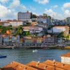 Cu vedere spre fluviul Douro, pitorescul cartier Ribeira din Porto urcă pe colină printre case istorice, biserici și palate, iar în dreapta se întrezărește monumentalul Pod Dom Luís I.