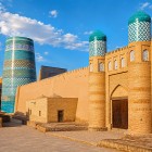 Kuhna Ark, vechea cetate a hanilor din Khiva, se dezvăluie printre ziduri impunătoare și turnuri crenelate: cărămida, portalurile și cupolele turcoaz evocă puterea Itchan Kala.