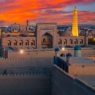 La apus, Madrasa Muhammad Rahim Khan II domină Itchan Kala, iar Minaretul Islam Khoja luminat se înalță deasupra vechii Khiva.
