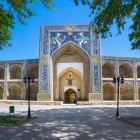Fațada Madrasei Nadir Divan-Begi întâmpină călătorul cu portalul impunător, simurghii și logiile decorate, mărturie a Buharei din secolul al XVII-lea.