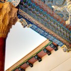 În complexul Bahauddin Naqshband, ayvanul Moscheii Khakim Kushbegi impresionează prin coloane, muqarnas și tavane pictate în stilul tradițional din Bukhara.