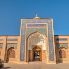 Marele portal al Complexului Bakhouddin Naqshband, decorat cu mozaicuri și inscripții, întâmpină pelerinii și vizitatorii în inima spirituală a Buharei sacre.