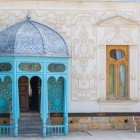 Ieșirea din Palatul Sitorai Mokhi Khosa îmbină stâlpi din lemn turcoaz, o cupolă metalică și stucaturi florale, o întâlnire rafinată între arta uzbecă și gustul european.