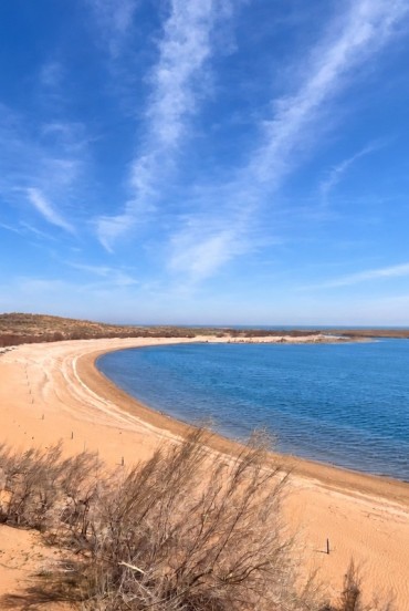 În deșertul Kyzylkum, Lacul Aydarkul întâlnește o plajă aurie întinsă: apele albastre și dunele presărate cu arbuști creează un peisaj natural surprinzător.