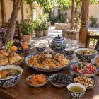 Într-un restaurant de familie din Nurata, călătorii descoperă ospitalitatea uzbecă savurând plov, shurpa, samsa, pâine non, achichuk, fructe uscate și ceai verde.