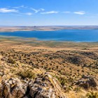 De sus apare lacul Aydarkul, o întindere surprinzătoare de apă lângă Kyzylkum. Contrastul cu munții arizi transformă panorama într-o imagine memorabilă.