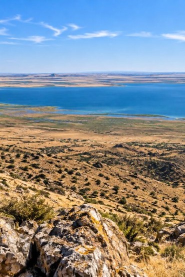 De sus apare lacul Aydarkul, o întindere surprinzătoare de apă lângă Kyzylkum. Contrastul cu munții arizi transformă panorama într-o imagine memorabilă.