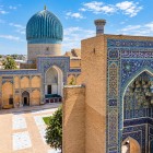 Din curte apare celebra cupolă turcoaz canelată, simbol al Gur-e Amir, care domină mausoleul unde se odihnesc Tamerlan și membri ai dinastiei timuride.