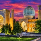 O vedere de ansamblu permite admirarea cupolei turcoaz, a portalurilor decorate și a turnurilor Gur-e Amir, elemente emblematice ale arhitecturii timuride din Samarkand.