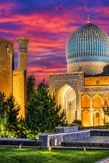 O vedere de ansamblu permite admirarea cupolei turcoaz, a portalurilor decorate și a turnurilor Gur-e Amir, elemente emblematice ale arhitecturii timuride din Samarkand.