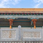 De-a lungul porticului, atenția se îndreaptă spre coloanele sculptate din lemn, tavanele pictate și balustradele traforate din piatră, expresii ale meșteșugului din Bukhara.
